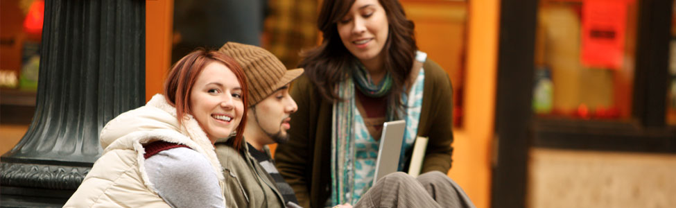three young adults looking at a computer