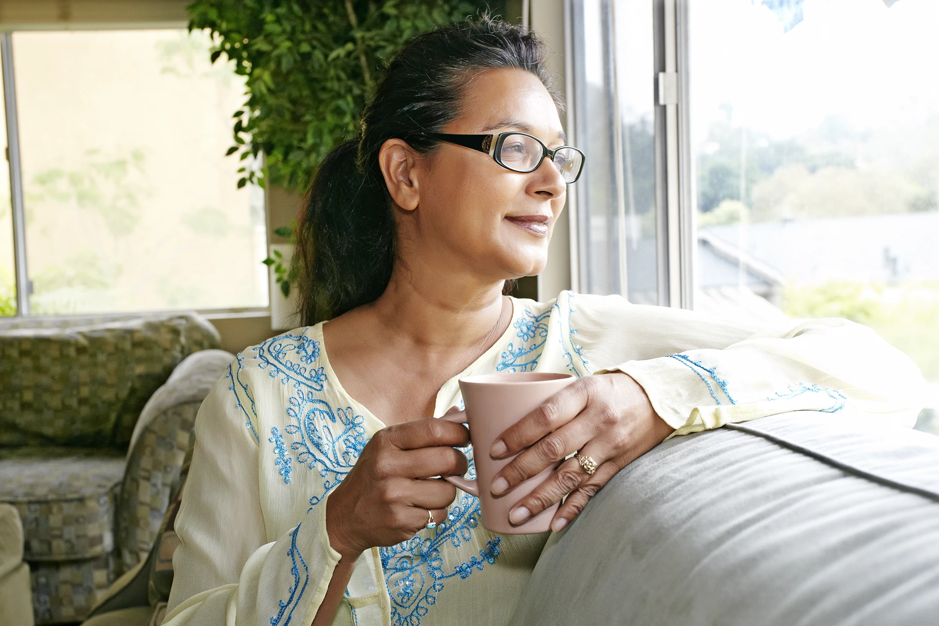 Woman sitting on couch holding coffee cup