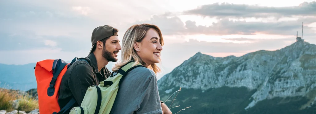 Couple of hikers taking a rest with mountain in background